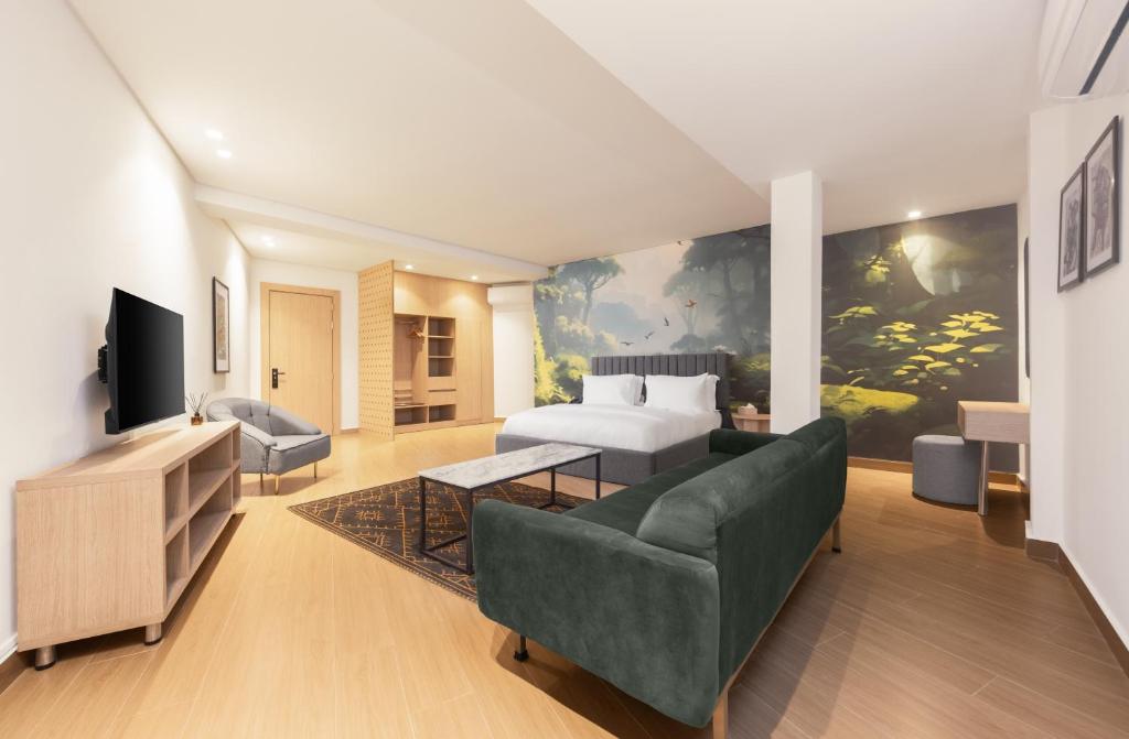 una camera con letto, divano e TV di Tree House Boutique Hotel ad Abuja