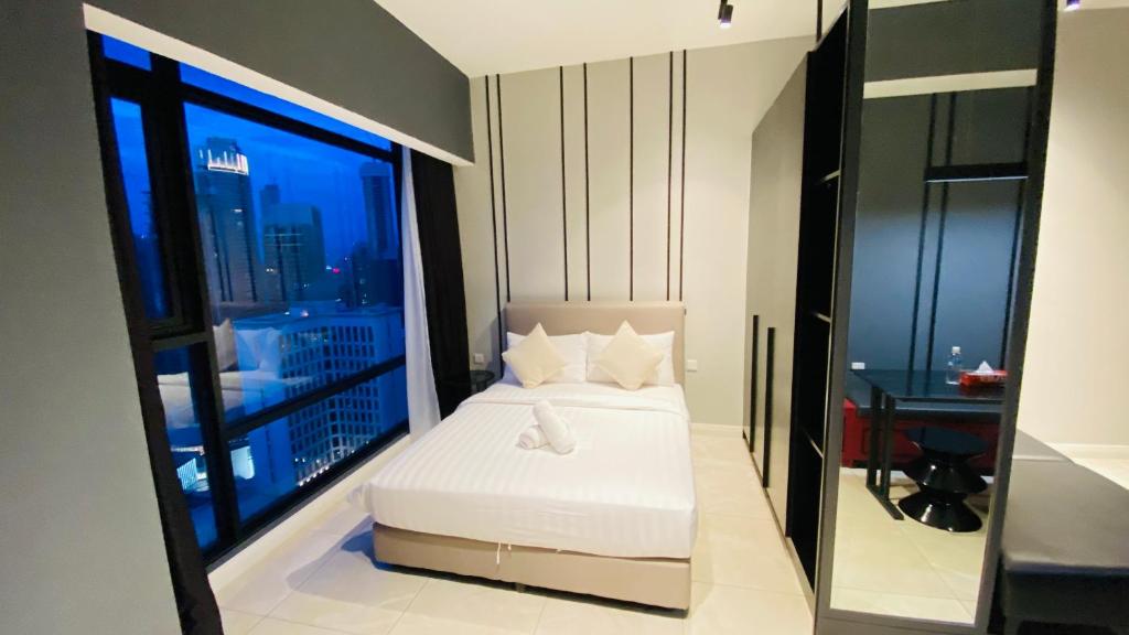 Axon suites by GALAXY HOUSE في كوالالمبور: غرفة نوم بسرير ونافذة كبيرة