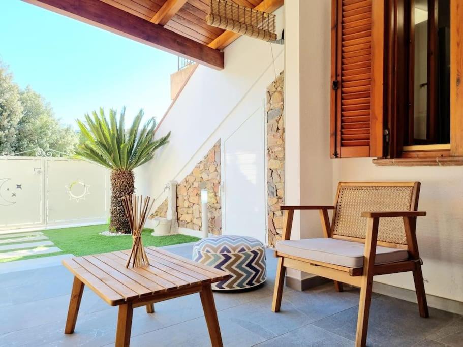 un patio con banco, mesa y silla en Best in Villasimius: modern, perfectly located, en Villasimius