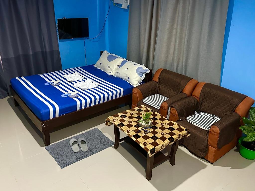 een kamer met een bed, een bank en een tafel bij Rozay Travellers Inn in Kabankalan