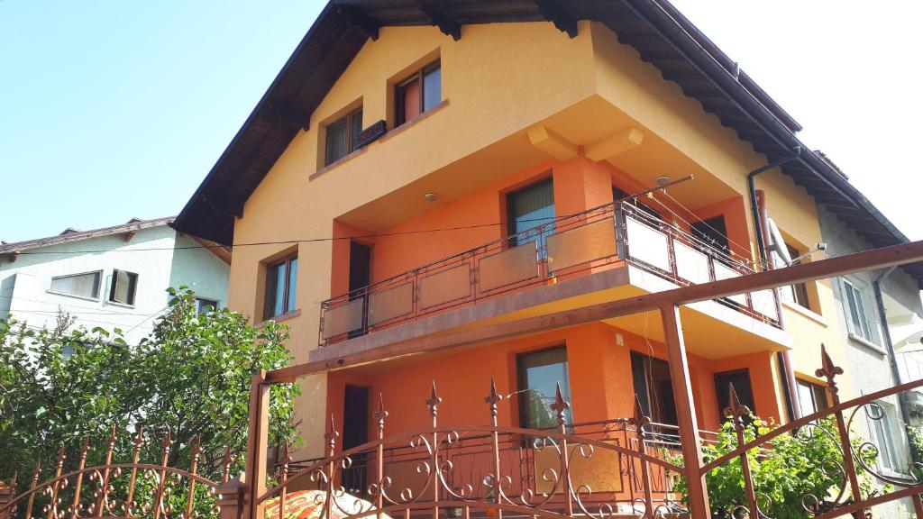 a yellow and orange building with a balcony at Guest House Blisten in Sofia