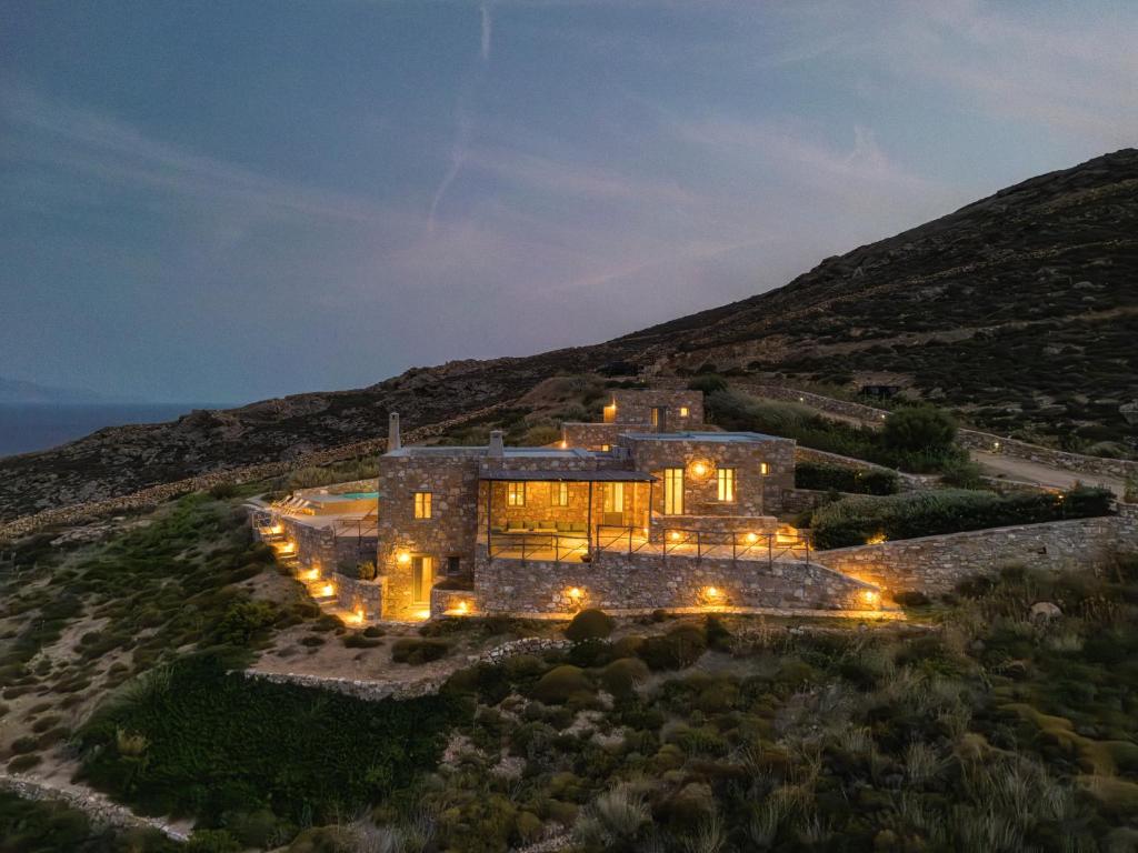 una vista aérea de una casa en una colina por la noche en Infinity Villa, luxury house with stunning view in Serifos, en Rámos