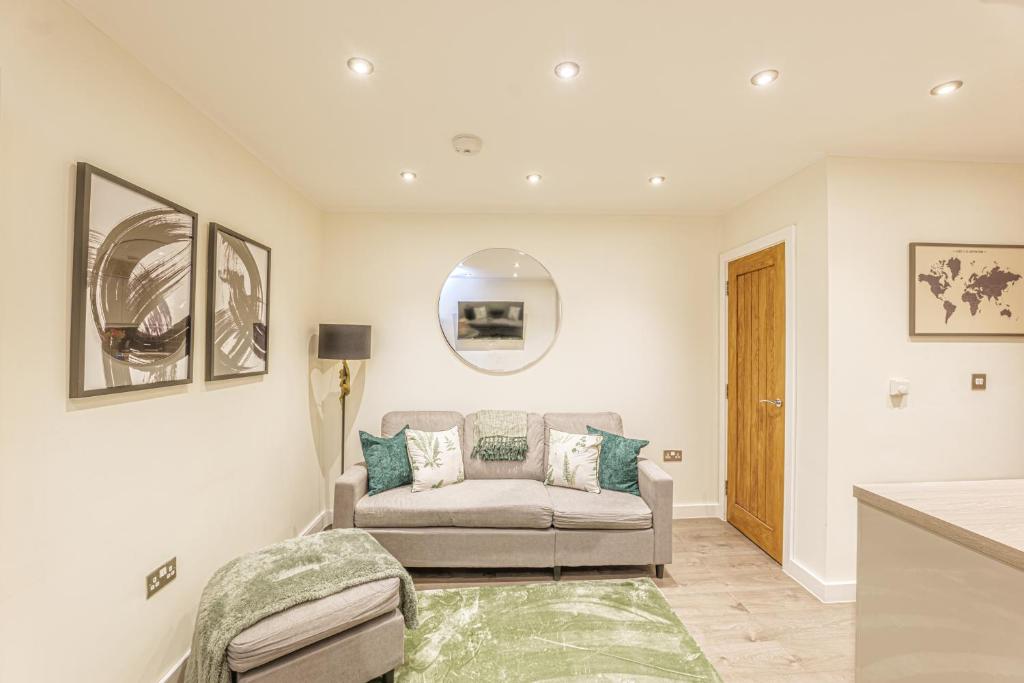 a living room with a couch and a mirror at Stylish & Central Homes in Bromley in Bromley