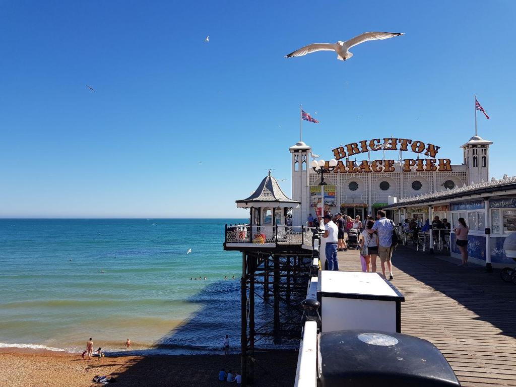 a pier with people on the beach and the ocean at Maldron Hotel Brighton City Centre in Brighton & Hove
