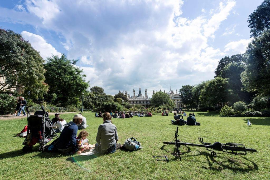 a group of people sitting on the grass in a park at Maldron Hotel Brighton City Centre in Brighton & Hove