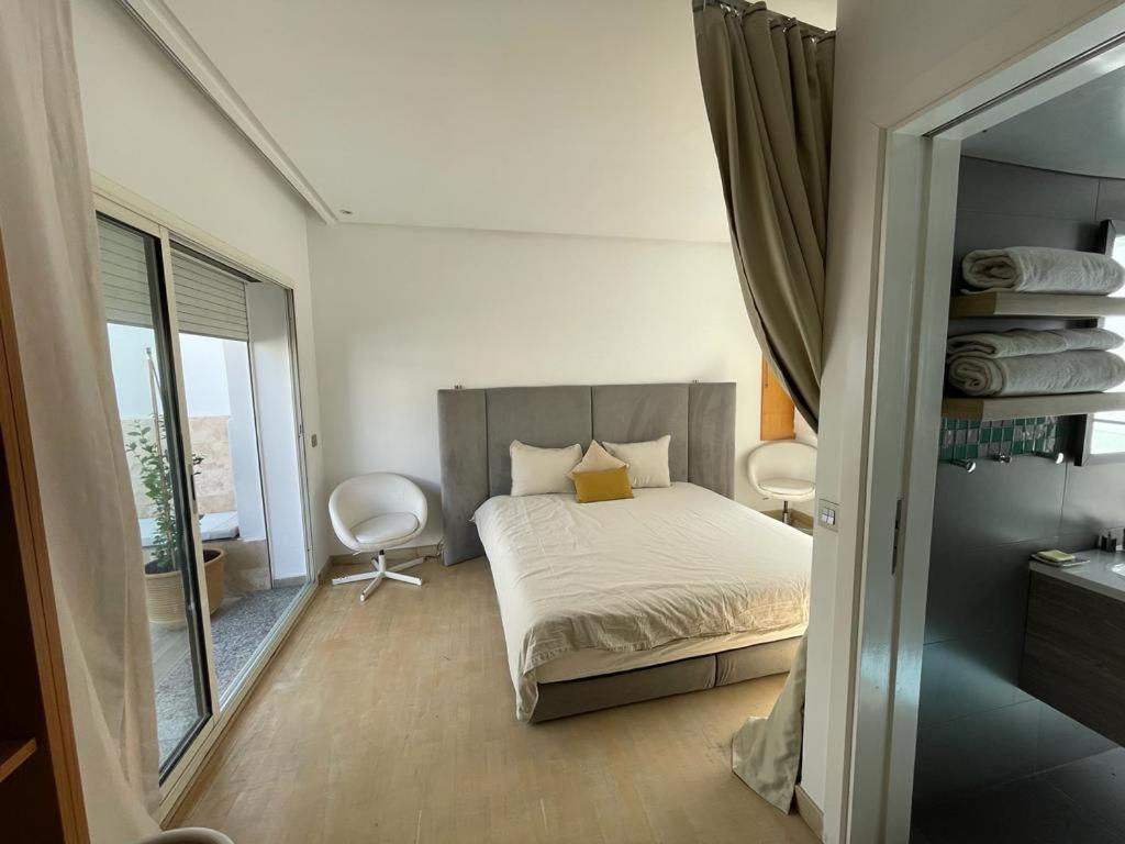 Dormitorio pequeño con cama y espejo en Central, terrasse, confortable - Bleue résidence en Casablanca