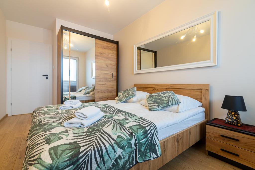 a bedroom with a bed and a mirror on the wall at Apartament z dwoma sypialniami i z miejscem postojowym in Białystok