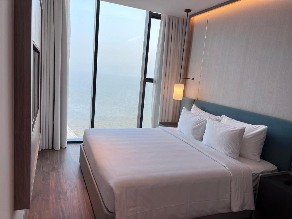 ein Schlafzimmer mit einem großen Bett und einem großen Fenster in der Unterkunft View Natural Wonders A La Carte Ha Long Bay VIE in Hạ Long