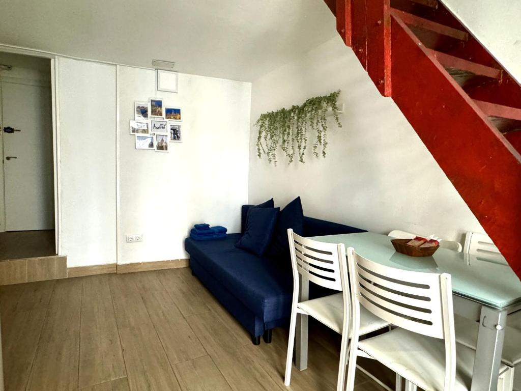 ein Wohnzimmer mit einem Tisch und einem blauen Sofa in der Unterkunft Apartamento con encanto en el corazón de Chueca, Madrid in Madrid