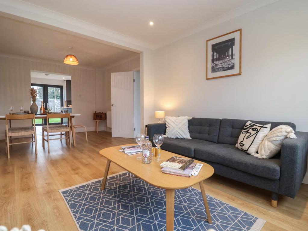 ein Wohnzimmer mit einem Sofa und einem Tisch in der Unterkunft Herring House in Lowestoft