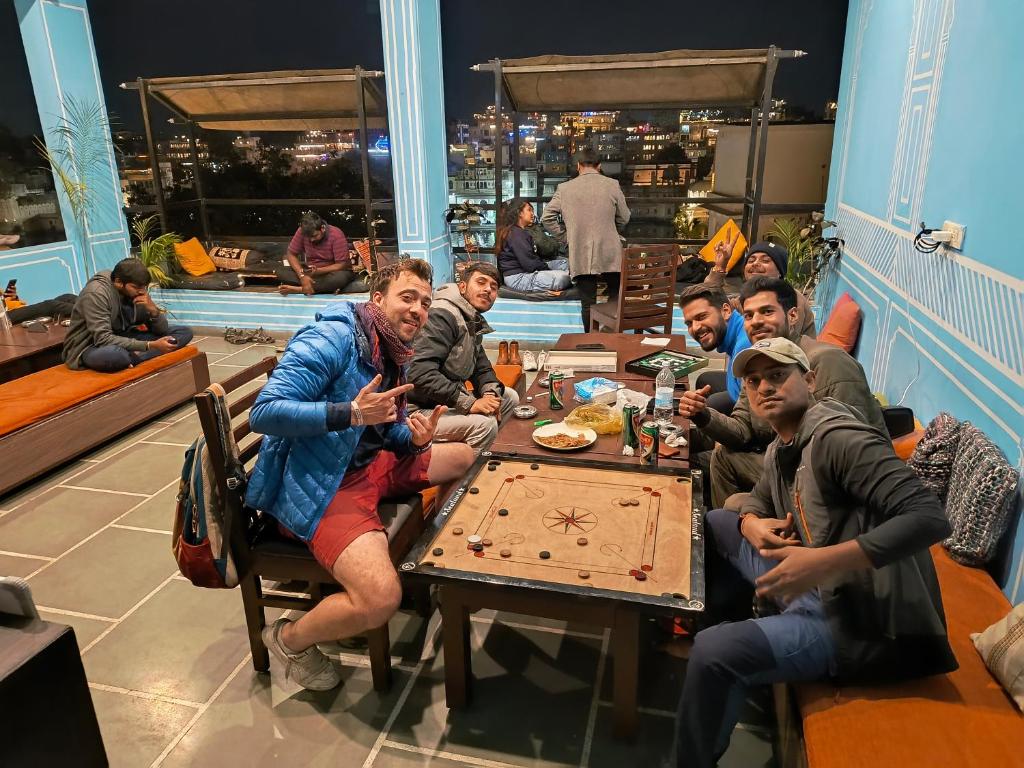 Eine Gruppe von Menschen, die an einem Tisch sitzen und essen in der Unterkunft Madpackers Udaipur in Udaipur