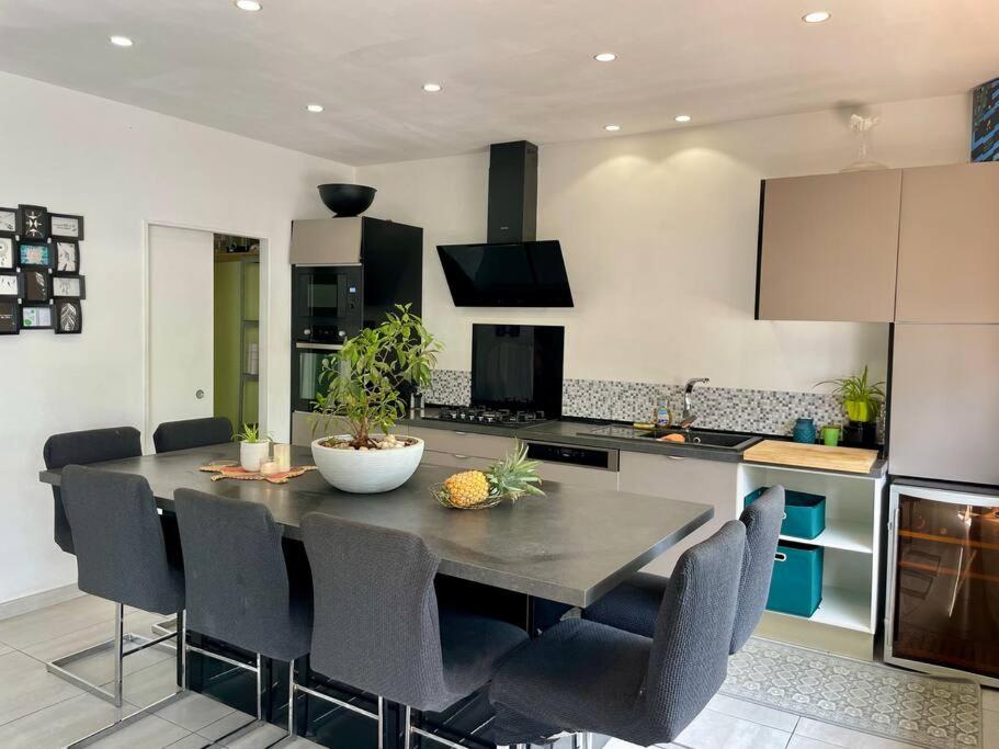a kitchen with a table and chairs in a room at Kaz Ajeya in Les Avirons