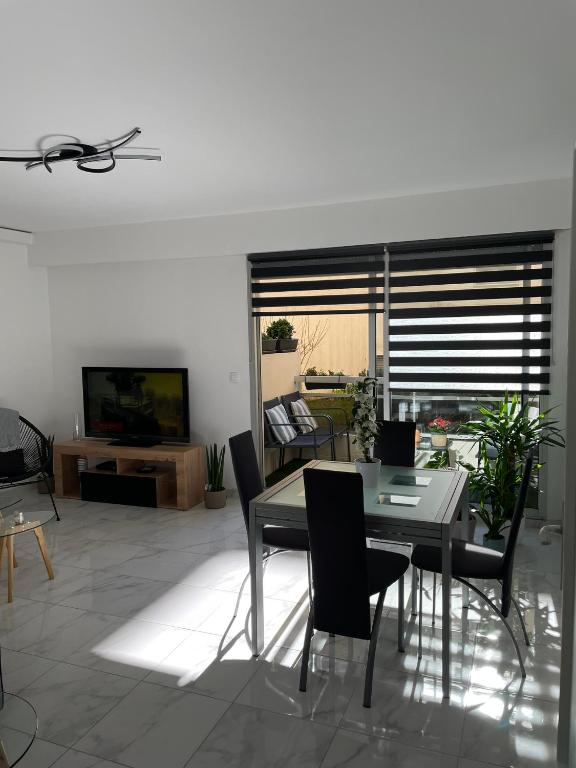 une salle à manger avec une table, des chaises et une télévision dans l'établissement Superbe appartement carré Delfino Port de Nice, à Nice