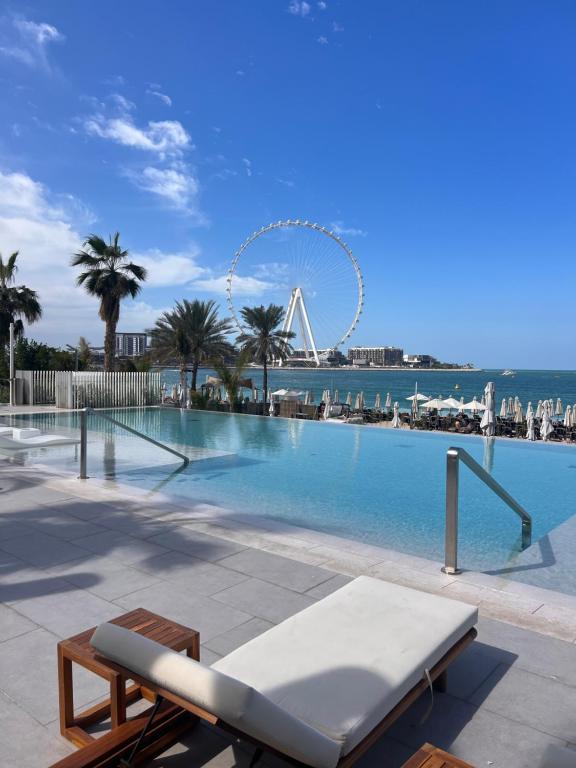 a large swimming pool with a ferris wheel in the background at Luxury apartment Beachfront escape in La Vie JBR in Dubai