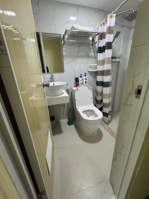 a bathroom with a toilet and a sink and a mirror at Studio Guest Suite Near The New EVRMC Hospital & San Juanico Bridge Tacloban City, Leyte, Philippines in Tacloban