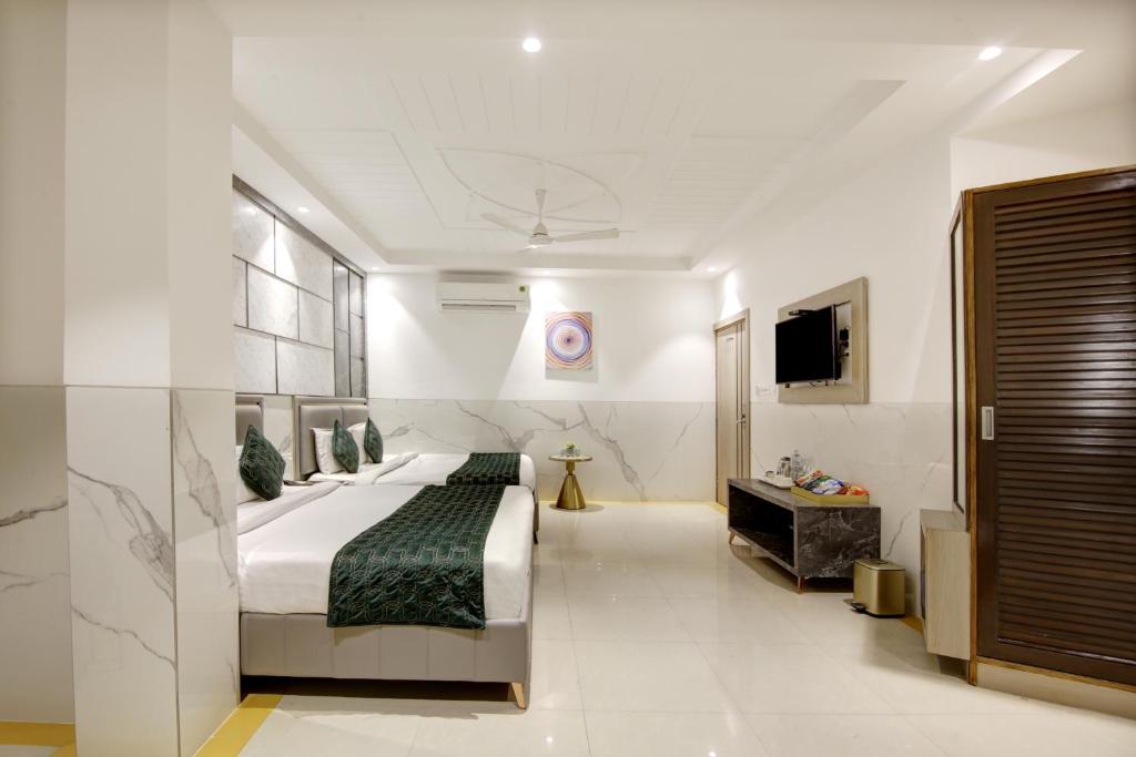 ein Hotelzimmer mit einem Bett und einem TV in der Unterkunft Hotel Delhi 37 by Star Group NEAR DELHI AIRPORT in Neu-Delhi