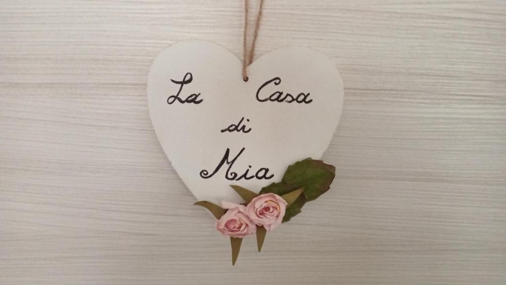 a heart ornament with two pink roses on a table at La Casa di Mia in Verona