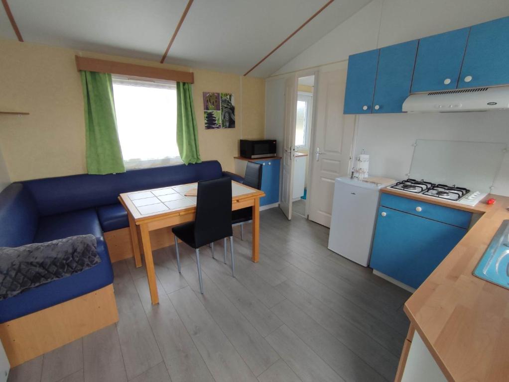 ein Wohnzimmer mit einem blauen Sofa und einem Tisch in der Unterkunft Mobil-home 2 