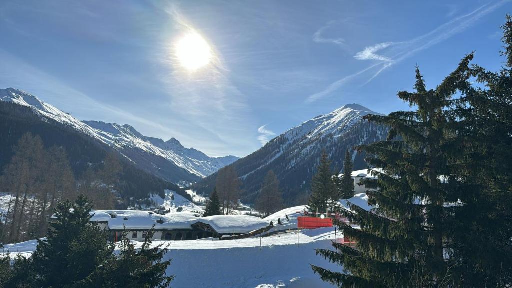 una montaña cubierta de nieve con el sol en el cielo en Chalet Studio - Top Ausstattung - beste Lage Davos, en Davos