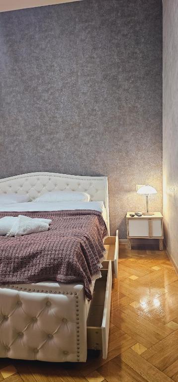 a bedroom with a bed and a night stand with a lamp at Memory basket in Kutaisi