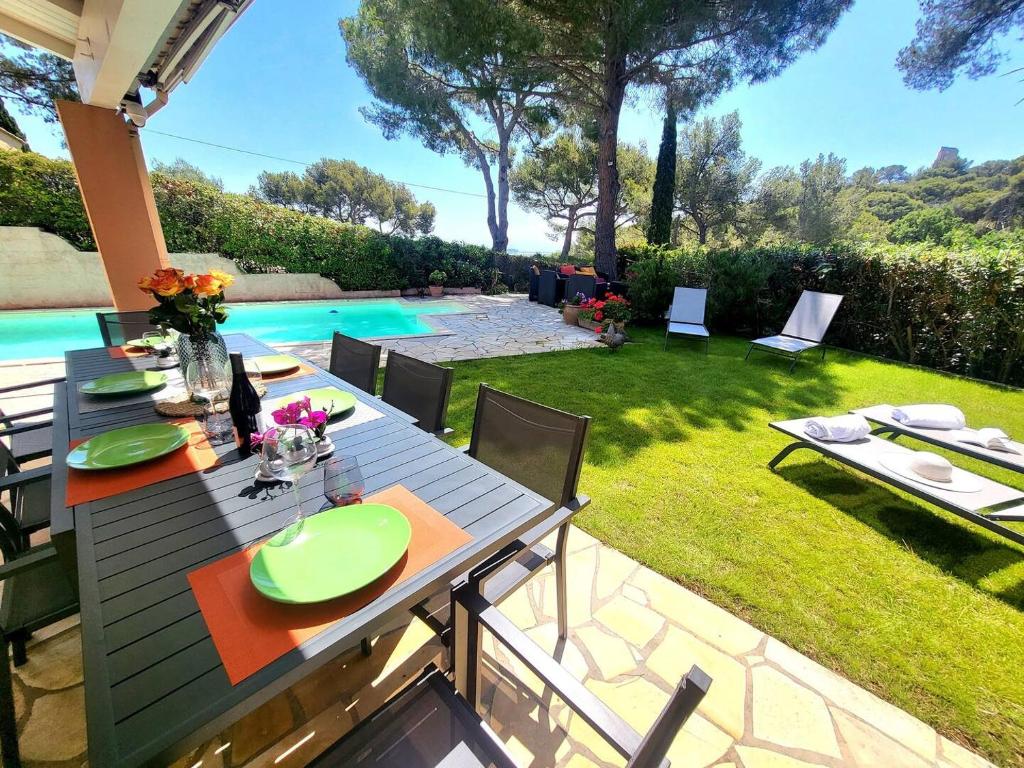 a patio with a table and chairs next to a pool at SmartStay - Hyeres villa vue mer in Hyères