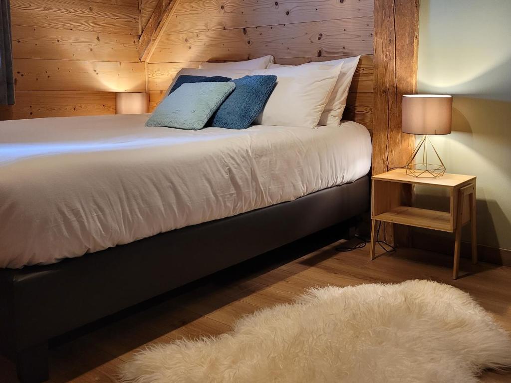モルジヌにあるChalet Lisaの白いベッド1台が備わる木製の壁のベッドルーム1室