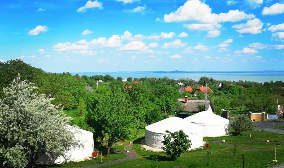 eine Gruppe weißer Zelte auf einem Feld mit dem Ozean in der Unterkunft Jurta Hotel Balatongyörök in Balatongyörök