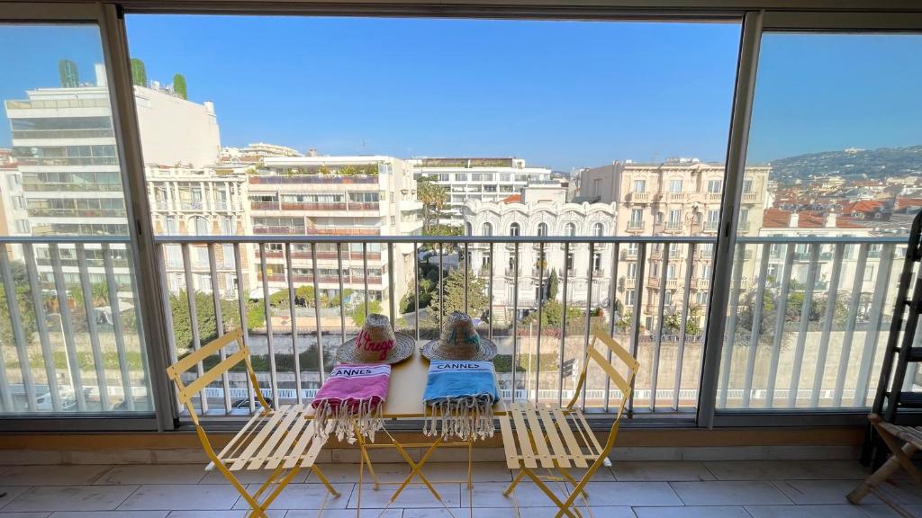 2 enfants sont assis sur des chaises sur un balcon dans l'établissement Cannes center - very practical - all comfort, à Cannes