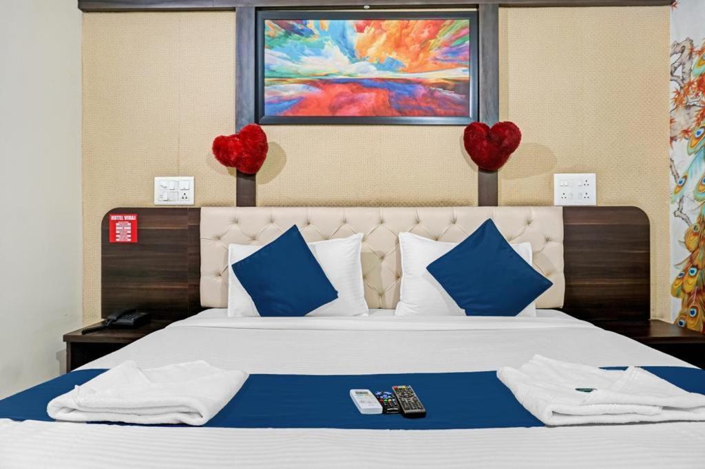 a bedroom with a bed with two red hearts on the wall at Hotel Viraj in Pune