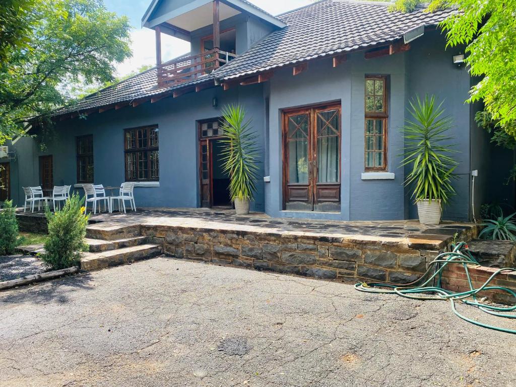 uma casa azul com plantas em frente em Boutique@Milner Guesthouse em Bloemfontein