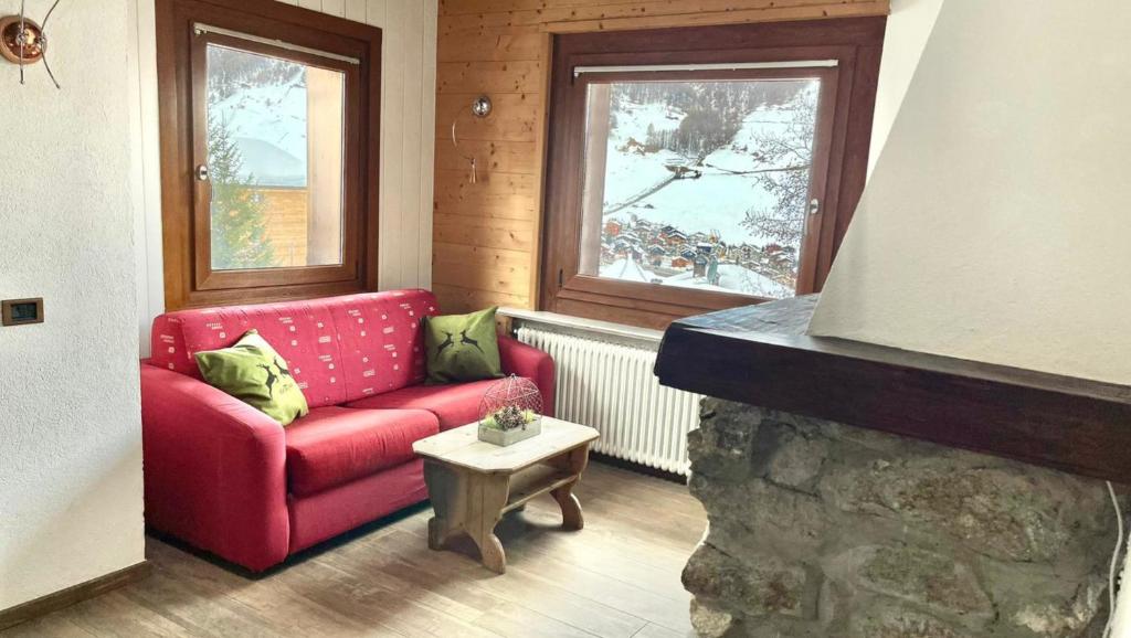 a living room with a red couch and a table at Appartamento Emanuel in Livigno