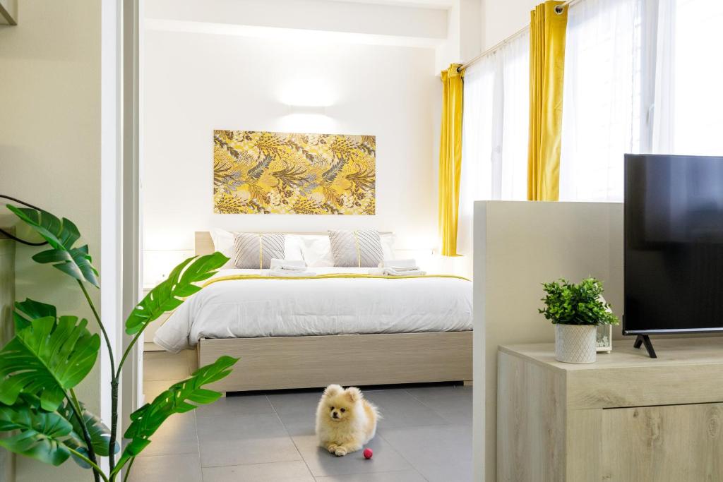 a bedroom with a bed with yellow curtains and a stuffed animal at San Felice Residence in Bologna