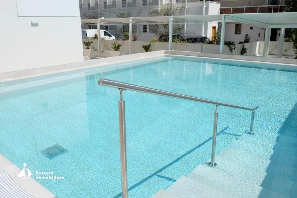 a large swimming pool with blue water in a building at Residence Bafjle 42 in Lido di Jesolo