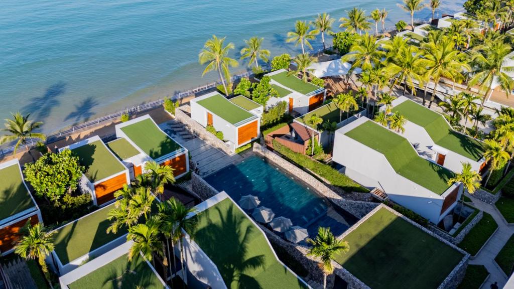 an aerial view of a resort with palm trees and the ocean at Casa De La Flora - SHA Extra Plus in Khao Lak