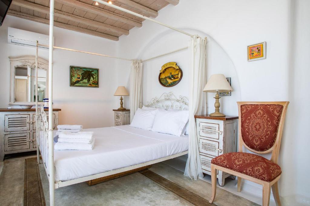 1 dormitorio con 1 cama blanca y 1 silla en Sea View Villa in Ornos en Ornos