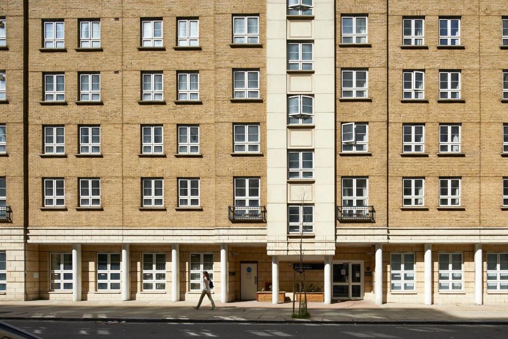 a person walks in front of a large brick building at Schafer House London in London