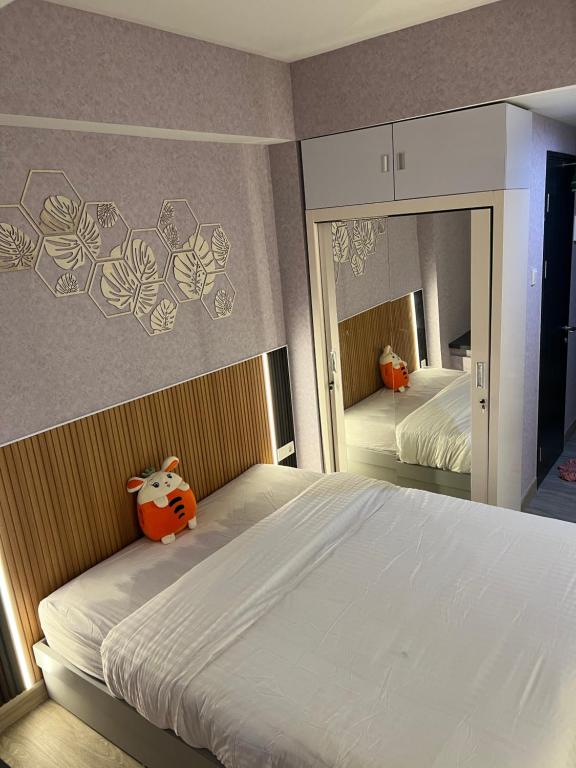 um quarto com uma cama grande e um espelho grande em Newly renovated apartement @ collins boulevard em Warungmangga