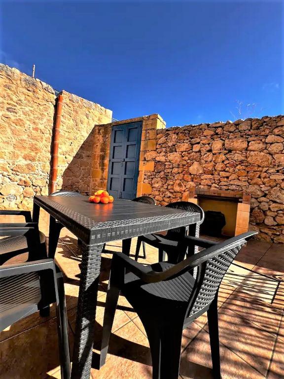 a black table and chairs on a patio at Ta’ Peppi Farmhouse in Qala