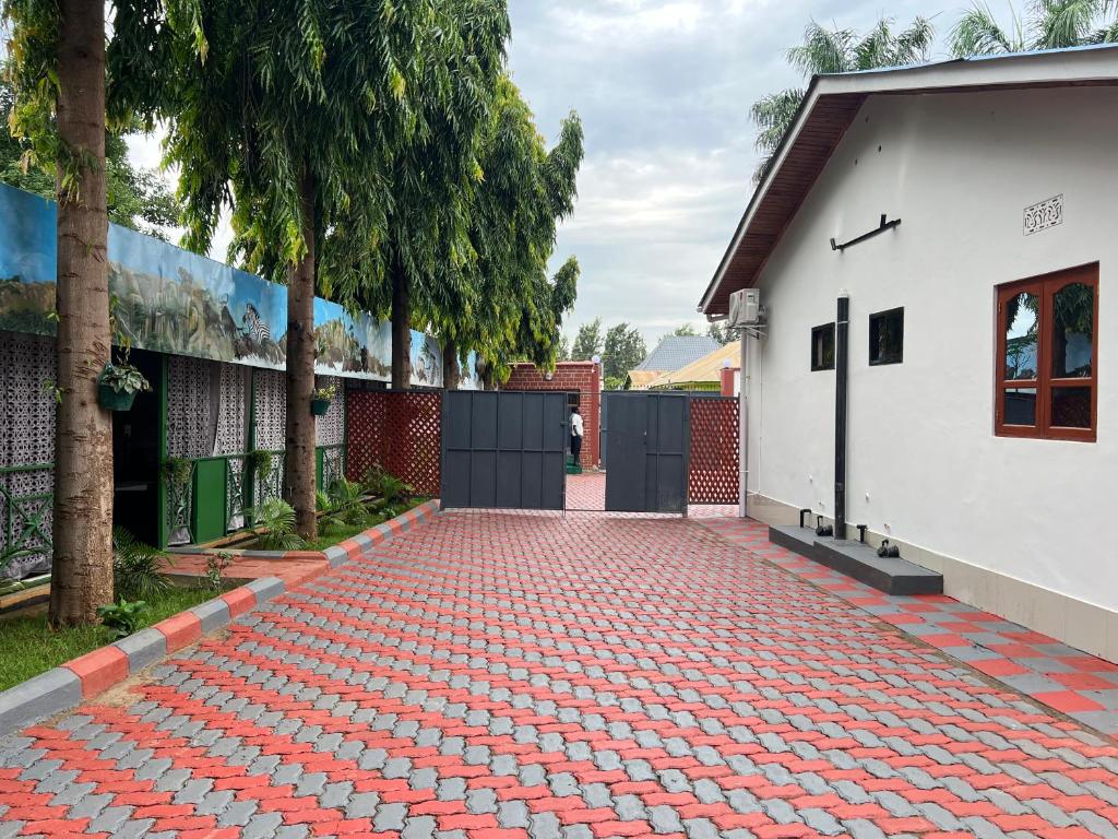 a red brick driveway next to a white building at Kilimanjaro Trekcity Hostel in Moshi