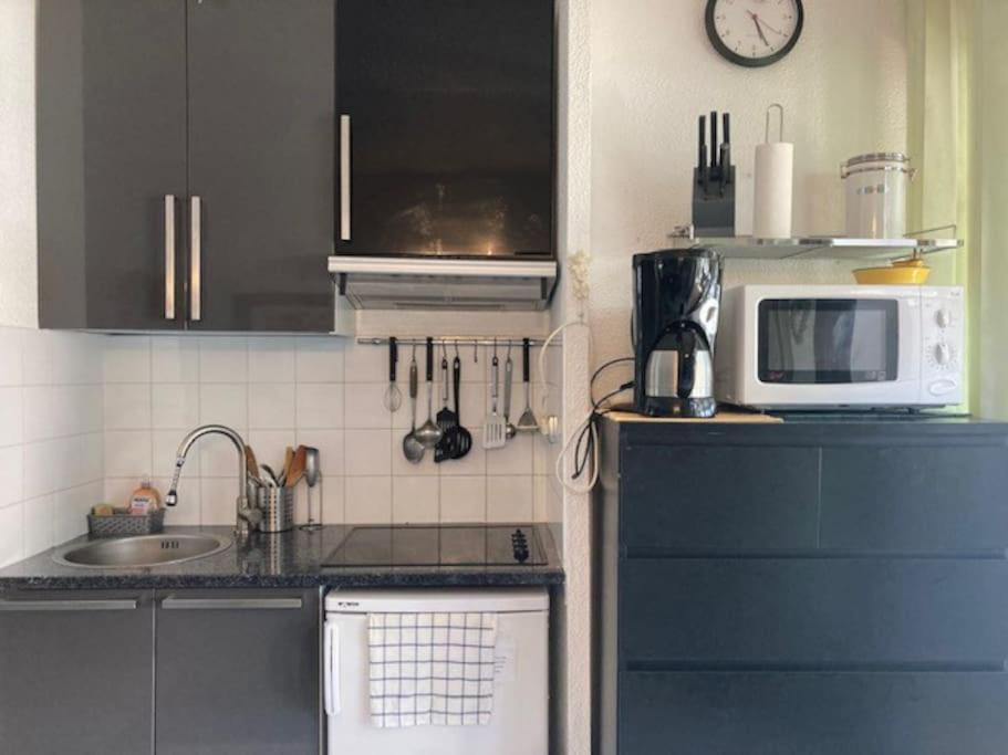 a kitchen with a microwave oven and a sink at Villa 53, Port Vénus au village naturiste in Cap d&#39;Agde