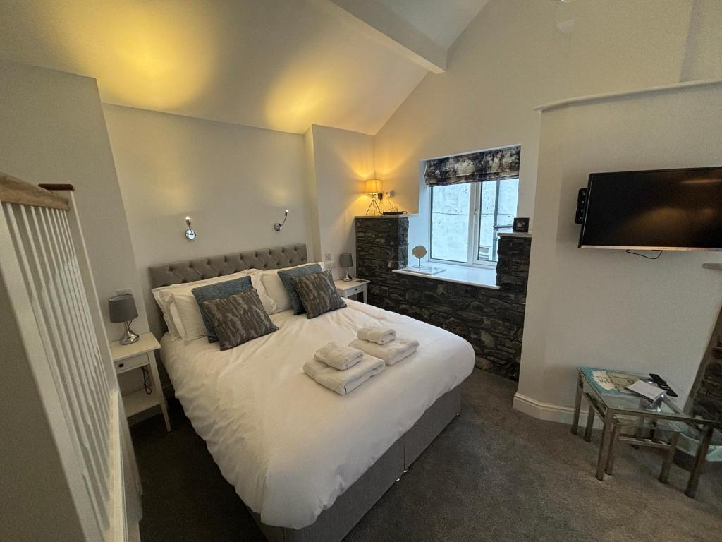 Un dormitorio con una cama blanca con toallas. en Braithwaite House Rooms en Braithwaite