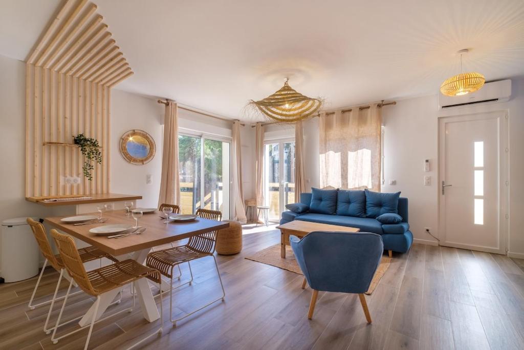 ein Wohnzimmer mit einem blauen Sofa und einem Tisch in der Unterkunft Magnifique pavillon indépendant T2 Nice in Nizza