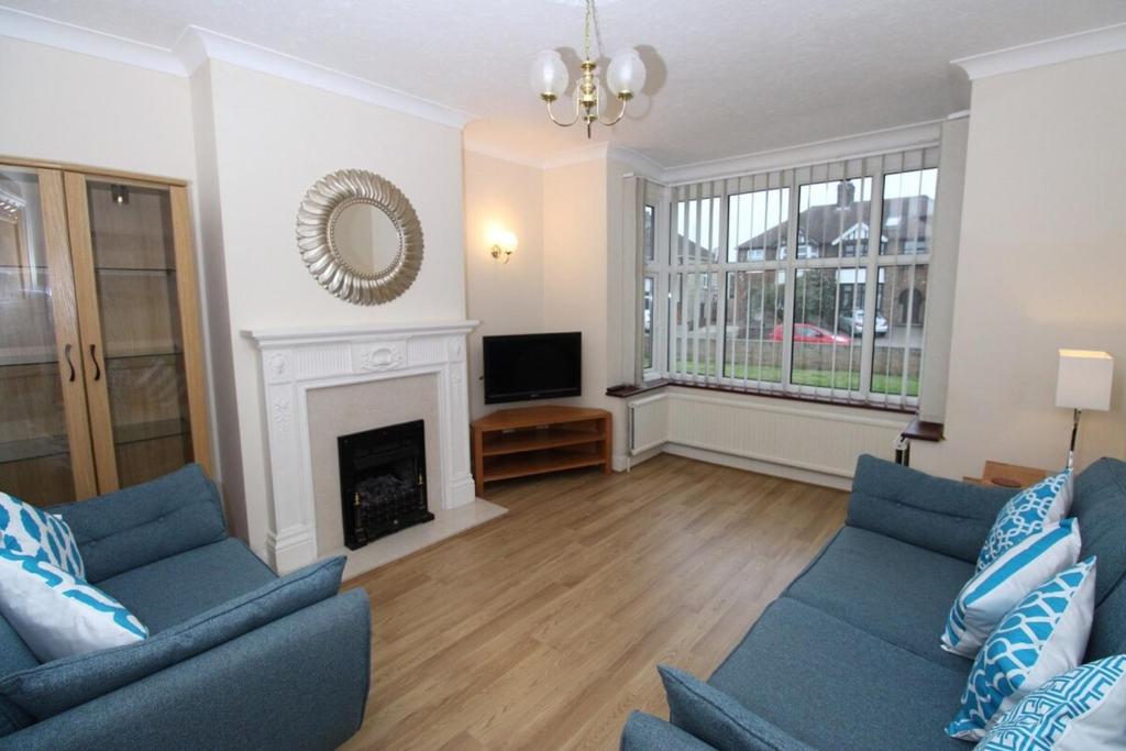 a living room with two blue couches and a fireplace at VERY SPACIOUS House For 6 In Fantastic Location in Cambridge