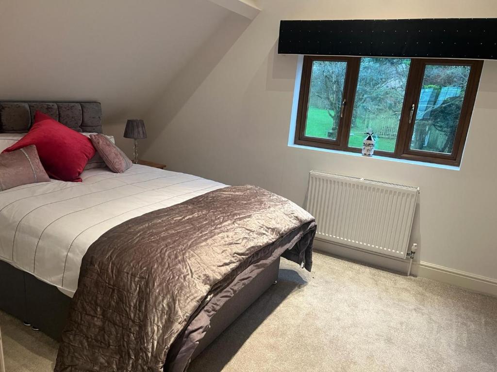 una camera da letto con un letto con cuscini rossi e una finestra di The Annex a Bristol