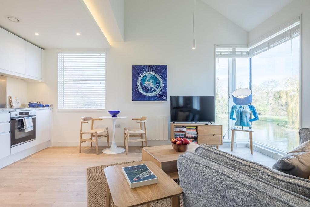 a living room with a couch and a table at Luxury City Centre Apartment - Stunning Water View in Cambridge