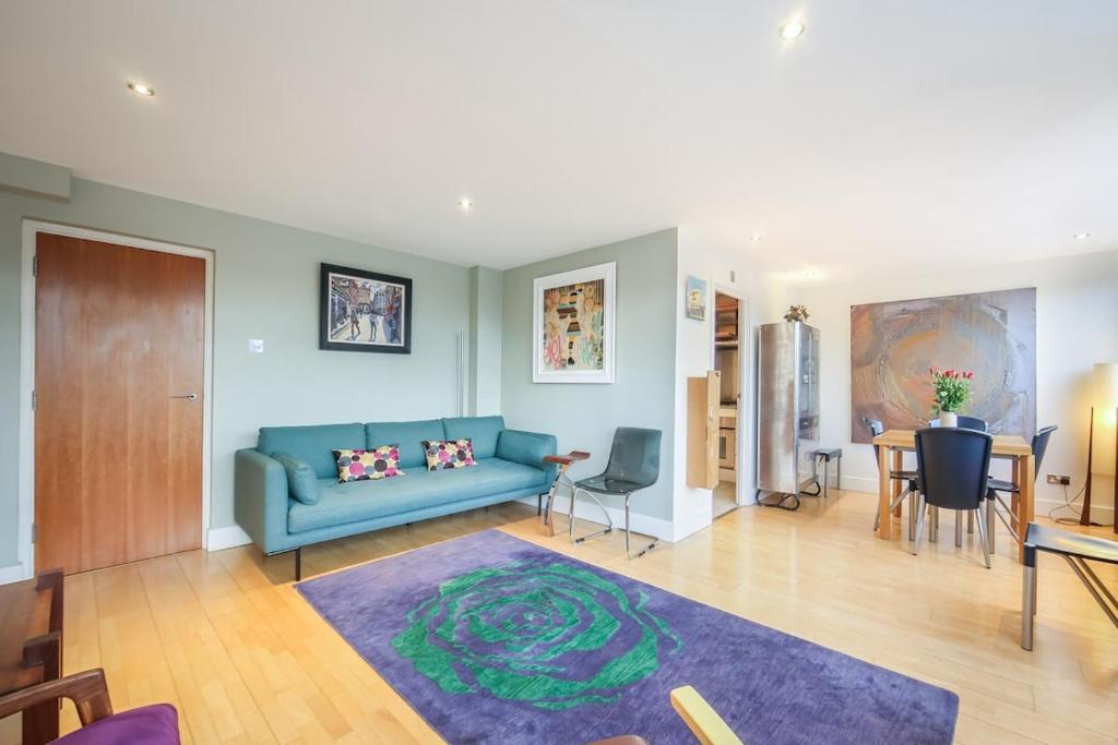 ein Wohnzimmer mit einem blauen Sofa und einem Tisch in der Unterkunft Large Luxurious CENTRAL Private Terrace - For 6 in London