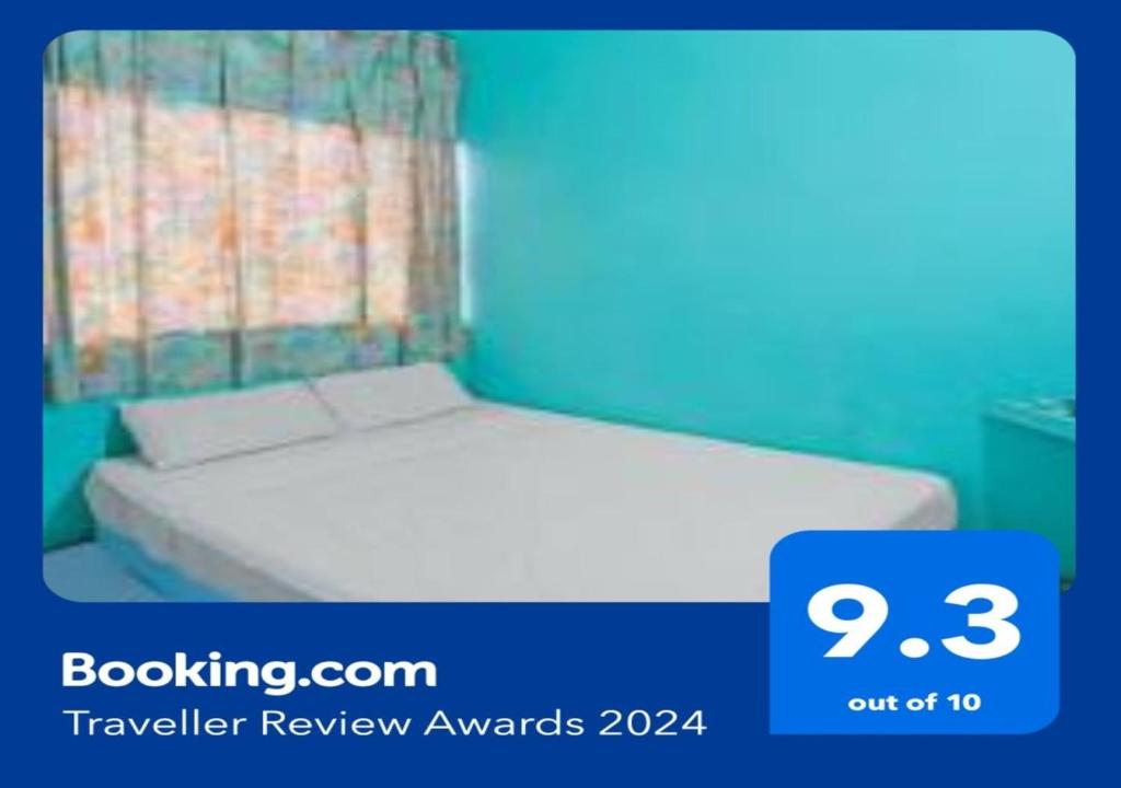 a bedroom with a bed with a blue wall at SPOT ON 91732 Rani Homestay Syariah in Jodoh