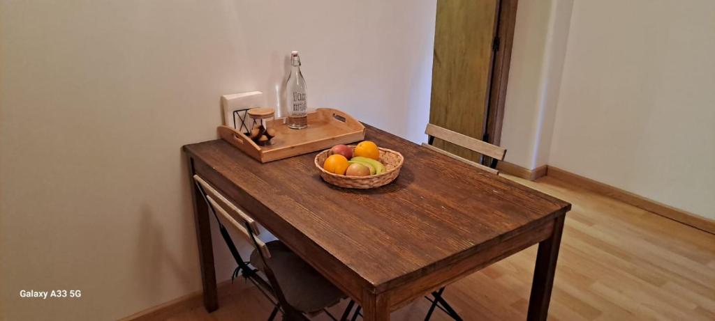 una mesa de madera con un bol de fruta. en Alojamiento compartido CanTroncxic en Sant Pere de Torelló