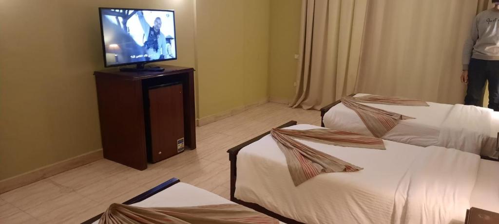 a hotel room with two beds and a flat screen tv at Sharm el shiekh sports city in Sharm El Sheikh