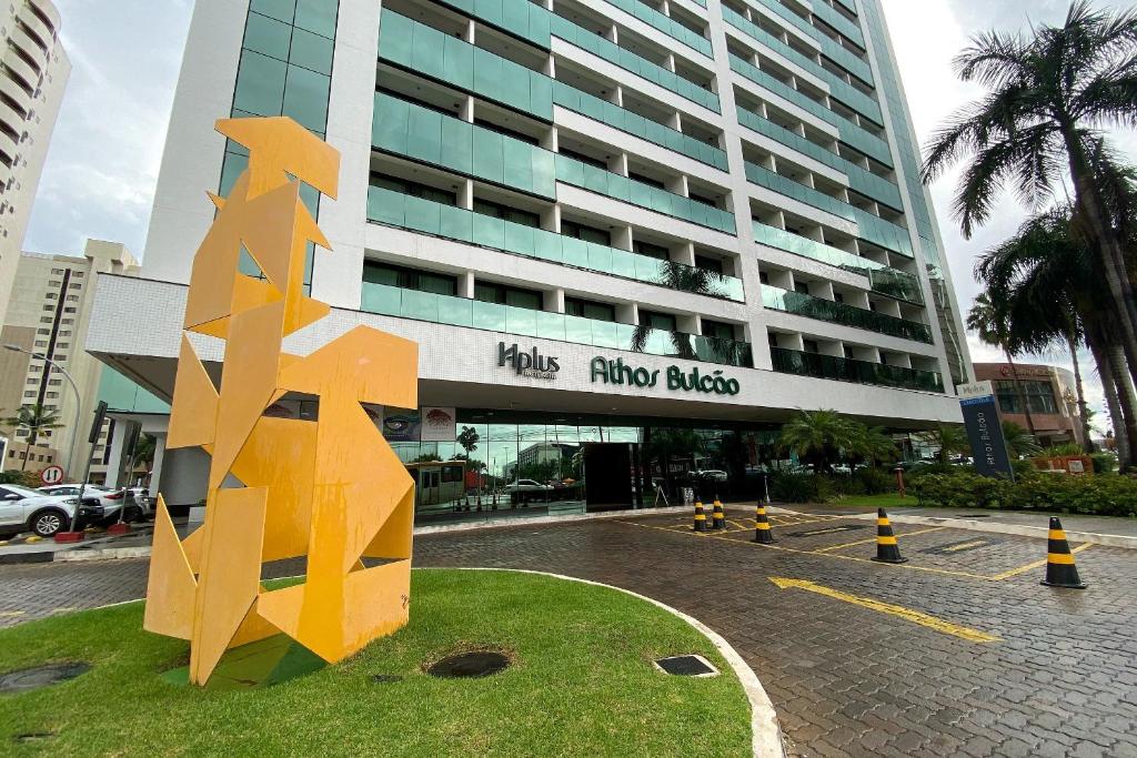 une grande sculpture jaune devant un bâtiment dans l'établissement Duplex Luxo Hotel Athos Bulcão Brasília - Ozped Flats, à Brasilia